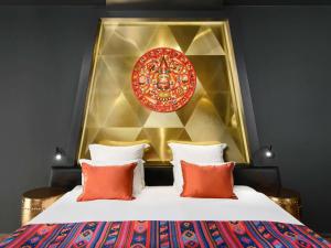sypialnia z łóżkiem z czerwonym i złotym zagłówkiem w obiekcie Minaro Hotel Tokaj MGallery - Adult Only w Tokaju