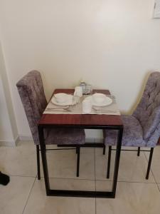 a table and two chairs with plates on it at Home away from home Next to Sky Louge Bamburi in Mombasa
