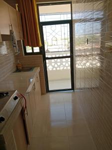 a kitchen with a window and a door to a room at Home away from home Next to Sky Louge Bamburi in Mombasa