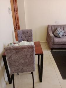 a living room with a table and a couch at Home away from home Next to Sky Louge Bamburi in Mombasa