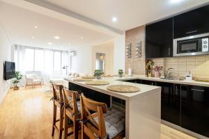 a kitchen with a large island in a kitchen with chairs at Malaga Center Flat Soho Modern 2BR in Málaga