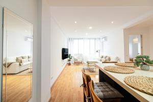 a living room with a table and chairs and a living room at Malaga Center Flat Soho Modern 2BR in Málaga