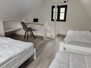 a bedroom with two beds and a desk and a chair at Chata Šimterka in Louka