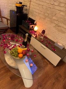 un tavolo con una ciotola di frutta e una bottiglia di vino di Oasis-spa a Praga