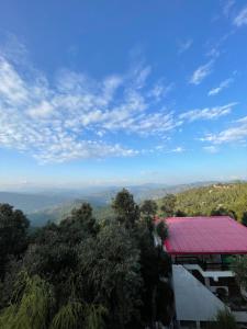 a view from the top of a mountain with a red roof at RAMARHYTHMS in Mukteswar