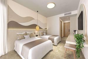 Habitación de hotel con 2 camas y mesa en Viva Miches by Wyndham, a Trademark All Inclusive Resort, en Miches