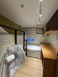 伊洛伊洛的住宿－Cozy 2 Bedroom End Unit，客房设有两张双层床和风扇。