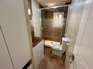 a small bathroom with a toilet and a shower at Malaga Center Flat Soho Modern 2BR in Málaga