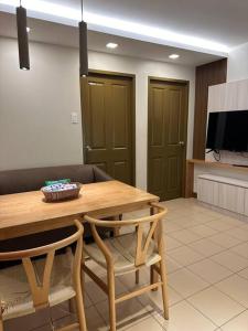 伊洛伊洛的住宿－Cozy 2 Bedroom End Unit，餐桌、两把椅子和电视