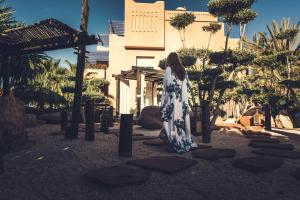 Una donna con un vestito in piedi davanti a un palazzo di Paradis Plage Surf Yoga & Spa a Taghazout