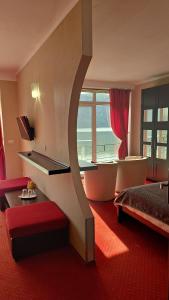 a hotel room with a bed and a large window at Pensiunea Decebal Resort - Cazanele Dunarii in Dubova