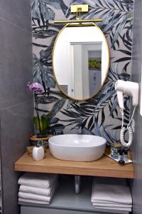 y baño con lavabo y espejo. en Gloden House Apartments, en Taormina