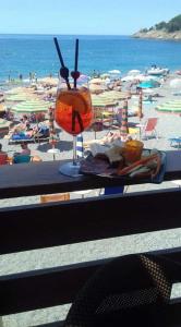 uma mesa com uma bebida na praia em CASA FELICITINA a pochi passi dal mare em Bonassola