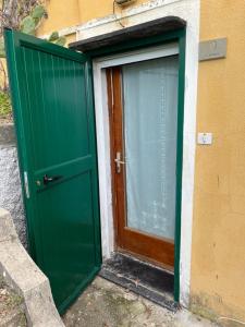 uma porta verde ao lado de um edifício em CASA FELICITINA a pochi passi dal mare em Bonassola