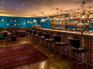 a bar with blue walls and bar stools at Suíte 5 estrelas Hotel Moema Times Square 1412 in Sao Paulo