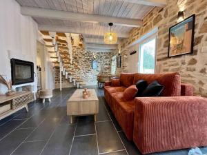 sala de estar con sofá y pared de piedra en Maison hyper centre Ville - 4 Pers - 2 places de Parking gratuites, en Quimper