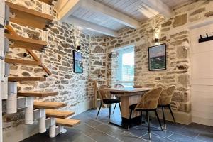 uma sala de jantar com paredes de pedra e uma mesa e cadeiras de madeira em Maison hyper centre Ville - 4 Pers - 2 places de Parking gratuites em Quimper