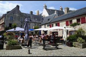 eine Gruppe von Menschen, die an Tischen in einem Innenhof sitzen in der Unterkunft Maison hyper centre Ville - 4 Pers - 2 places de Parking gratuites in Quimper