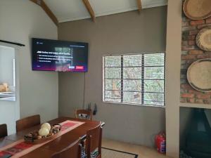 ein Esszimmer mit einem TV an der Wand in der Unterkunft The Blyde Canyon House in Hoedspruit