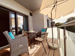 a patio with a table and chairs and an umbrella at Holiday apartment Beach54´Damp in Damp