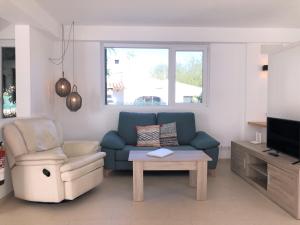 カラ・エン・ブラネスにあるNure Villas Mar y Marのリビングルーム(青いソファ、椅子付)