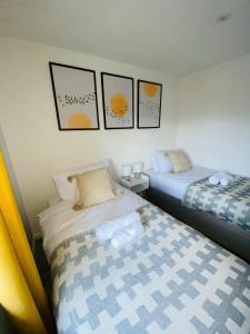 ファーンバラにあるHome in Farnborough with Free Parking, Wifi & Netflixのベッド2台が隣同士に設置された部屋です。
