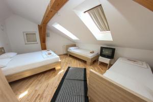 a attic bedroom with two beds and a tv at Hotel Hayat in Sarajevo