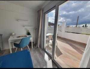 a room with a desk and a view of a balcony at Aquamarine in Voroklini