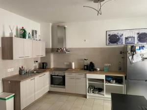 a kitchen with white cabinets and a stainless steel refrigerator at Im Herzen von Bochum in Bochum