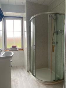 ein Bad mit einer Dusche und einem Waschbecken in der Unterkunft Kingarth Hotel in Kilchattan