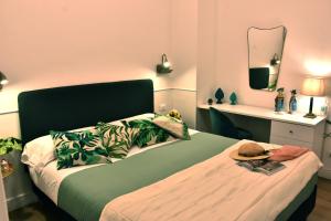 1 dormitorio con 1 cama grande y cabecero verde en Gloden House Apartments, en Taormina