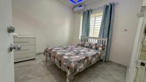 a bedroom with a bed in a room with a window at Prime Residence Apartments in Sukuta