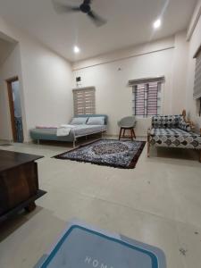 een woonkamer met 2 banken en een blauw tapijt bij 2 Bedroom Apartment near Vijayanagar, Bangalore in Bangalore