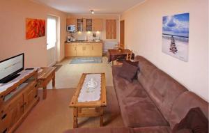 ein Wohnzimmer mit einem Sofa und einem Tisch in der Unterkunft Lovely Apartment In Heringsdorf seebad With Kitchen in Bansin