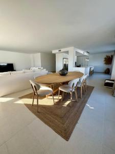 a dining table and chairs in a living room at Spacieux Appartement 3 chambres Reserva Sotogrande in San Roque