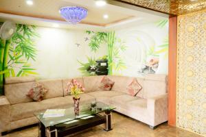 een woonkamer met een bank en een tafel bij Hotel Olive Greens in Jaipur