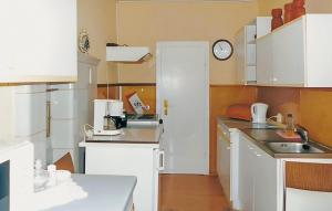 eine kleine Küche mit weißen Schränken und einem Waschbecken in der Unterkunft Cozy Home In Tambach-dietharz With Kitchen in Tambach-Dietharz