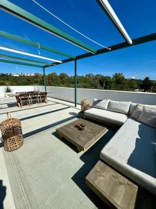 a patio with a couch and a table on a roof at Spacieux Appartement 3 chambres Reserva Sotogrande in San Roque