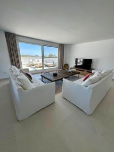 two white couches in a living room with a large window at Spacieux Appartement 3 chambres Reserva Sotogrande in San Roque