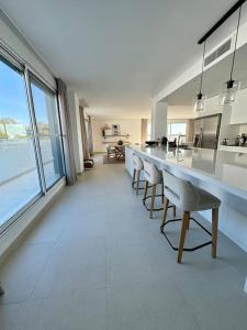 a large kitchen with a long table and chairs at Spacieux Appartement 3 chambres Reserva Sotogrande in San Roque
