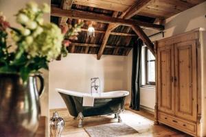 a bathroom with a bath tub and a vase of flowers at Ferienhaus in Klingenthal mit Garten und Terrasse in Klingenthal