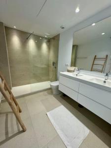 a bathroom with a sink and a toilet and a mirror at Spacieux Appartement 3 chambres Reserva Sotogrande in San Roque