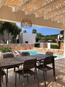 カラ・エン・ブラネスにあるNure Villas Mar y Marのパティオ(テーブル、椅子付)、プールが備わります。