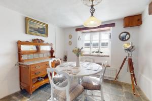 a dining room with a table and chairs and a camera at Captains Cottage Minehead in Minehead