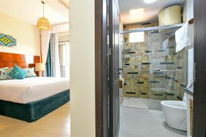 a bedroom with a bed and a bathroom with a shower at Hotel 256 Kampala, Kigo in Kampala