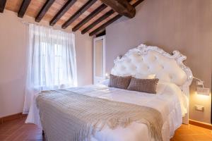 una camera da letto con un grande letto bianco e una finestra di Villa Le Polle di Meletro a Chianni