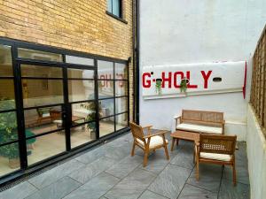uma loja com duas cadeiras e um banco num pátio em Hackney 1 Bed Garden Flat em Londres