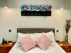 um quarto com uma cama com duas almofadas cor-de-rosa em Hackney 1 Bed Garden Flat em Londres