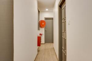 a hallway with an orange clock on the wall at OYO Townhouse 591 Hotel Woodland in Nagpur