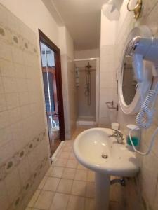 un bagno con lavandino, specchio e doccia di Siculè B&B a Catania Altre 30 foto